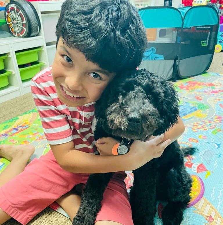 Website PM Bauer boy hugging a small dog